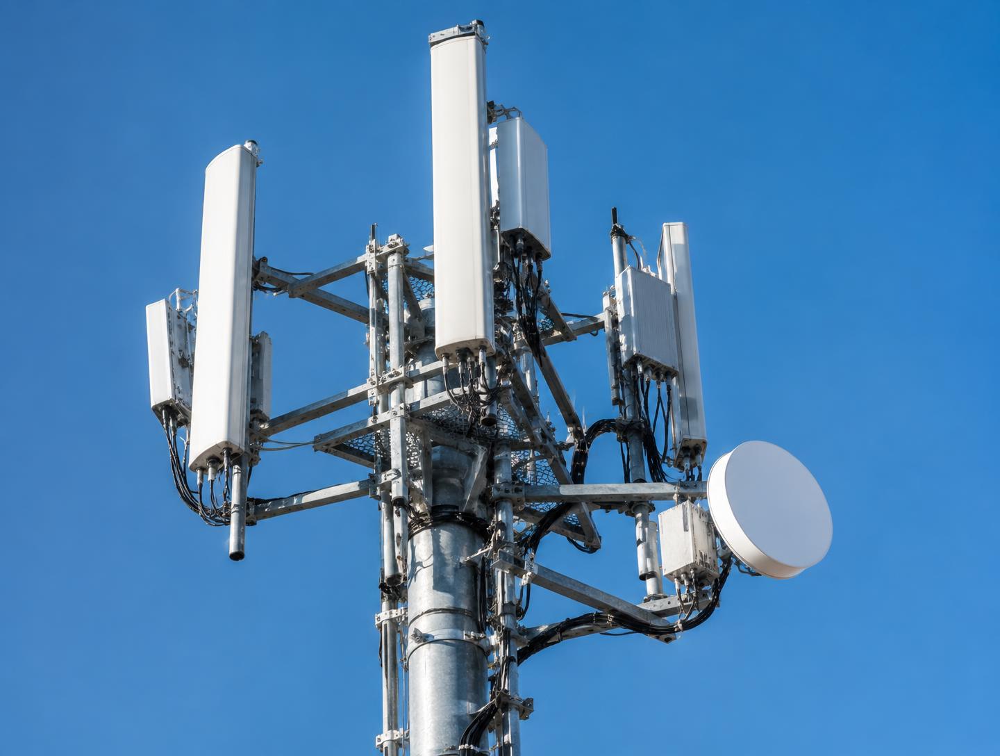 Communications mast and security infrastructure against an overcast sky