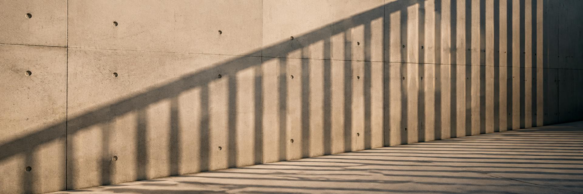 Concrete wall with fence shadow